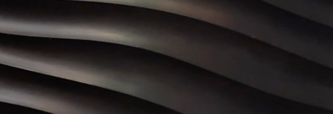 Dark sculptural relief with flowing wave-like surfaces